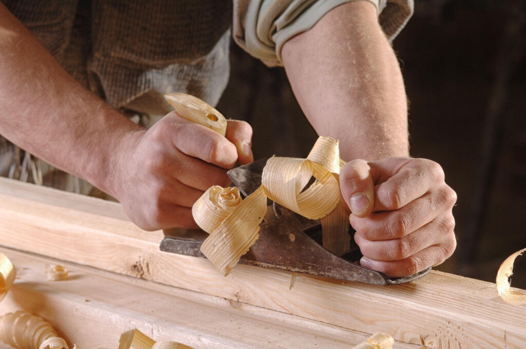Holzbearbeitung mit Handhobel in der Werkstatt